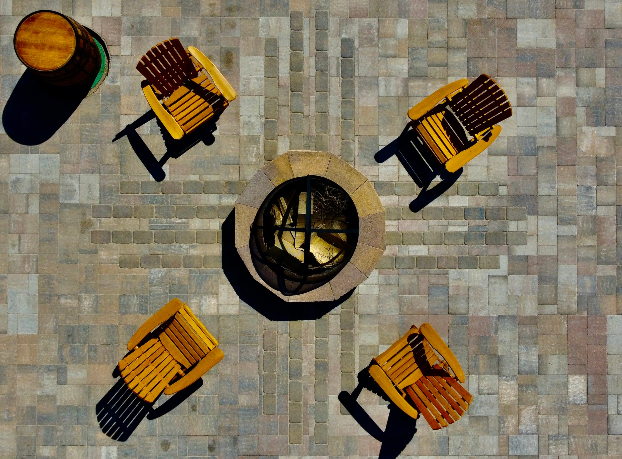 Custom patio seating area with inlaid Zia symbol and fire pit hardscape in Farmington NM by High Desert NativeScapes