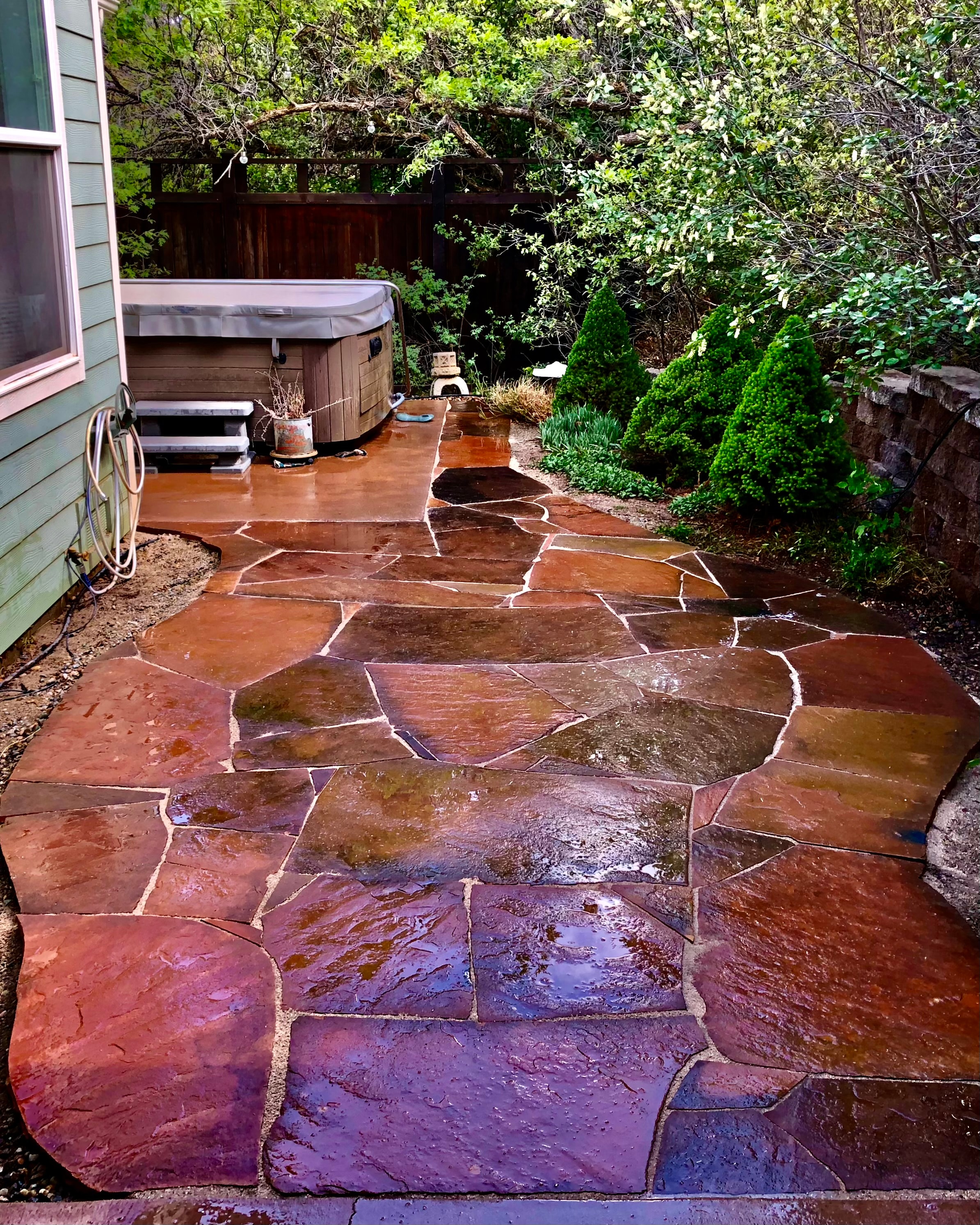Backyard patio with hot tub and stone pathway hardscape in the Four Corners area by High Desert NativeScapes